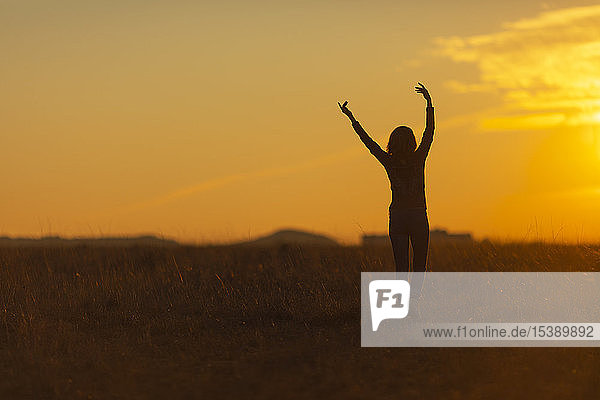 Frau geht bei Sonnenuntergang in der Natur spazieren