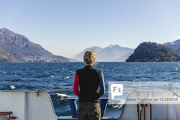 Italy  Como  rear view of woman on the ferry enjoying the view of Lake Como
