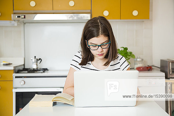 Mädchen benutzt Laptop in der Küche