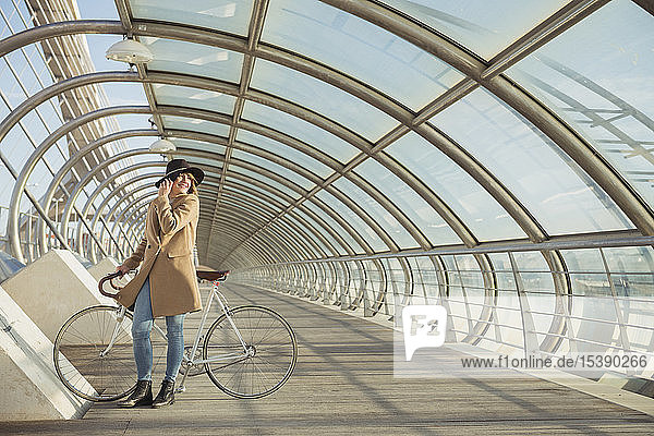 junge Hipster-Frau mit einem Fahrrad in einem modernen Tunnel
