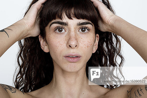 Portrait of tattooed young woman with freckles