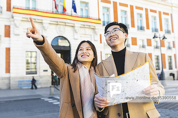 Spanien  Madrid  glückliches junges Paar mit Stadtplan  das die Stadt erkundet