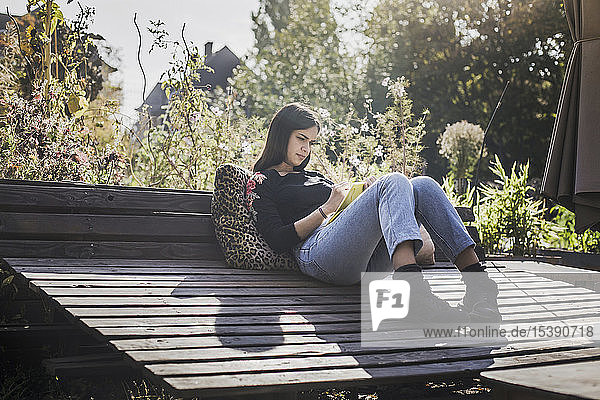 Frau entspannt sich im städtischen Garten und schreibt im Notizbuch