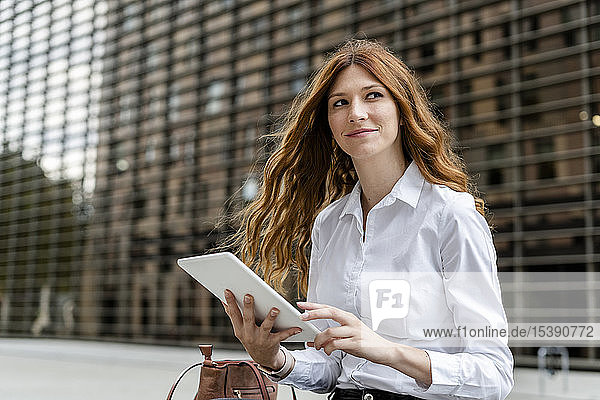 Junge Geschäftsfrau in der Stadt  die ein digitales Tablet benutzt