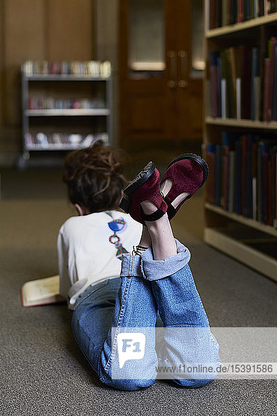 Female student reading book in a public library
