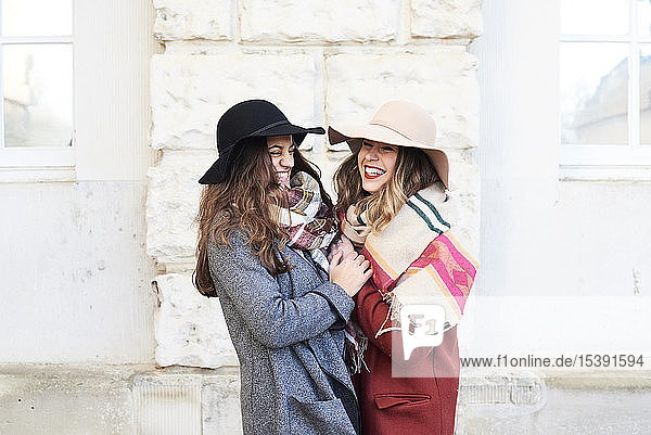 Two happy playful women wearing floppy hats