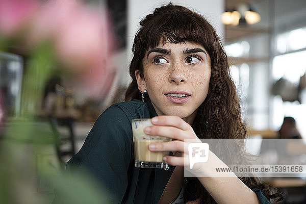 Porträt einer jungen Frau  die sich in einem Café umsieht