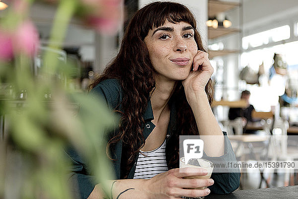 Porträt einer selbstbewussten jungen Frau in einem Cafe