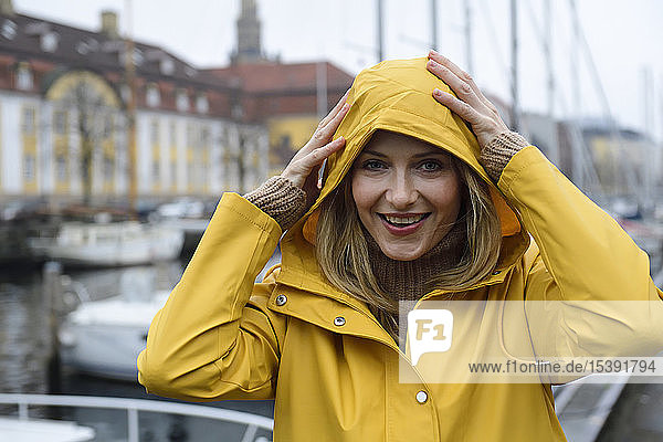 Dänemark  Kopenhagen  Porträt einer glücklichen Frau im Stadthafen bei Regenwetter