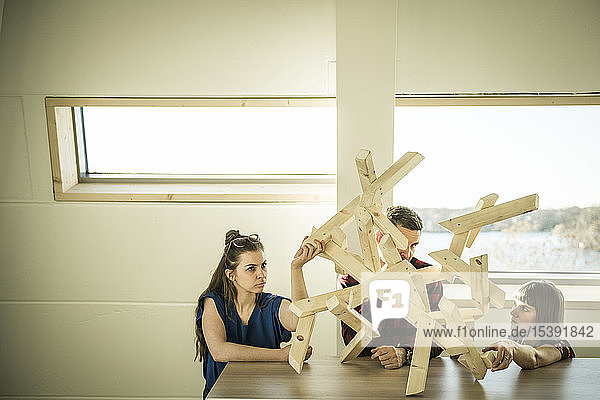 Group of creative professionals building wood object for a project