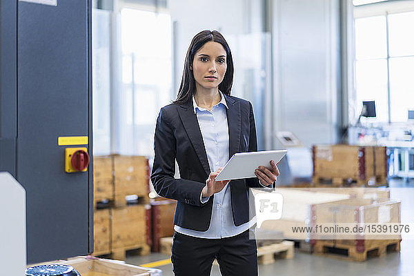 Portrait of businesswoman using tablet in a factory