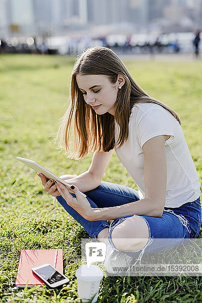 Junge Frau erkundet New York City  macht eine Pause und benutzt ein digitales Tablet