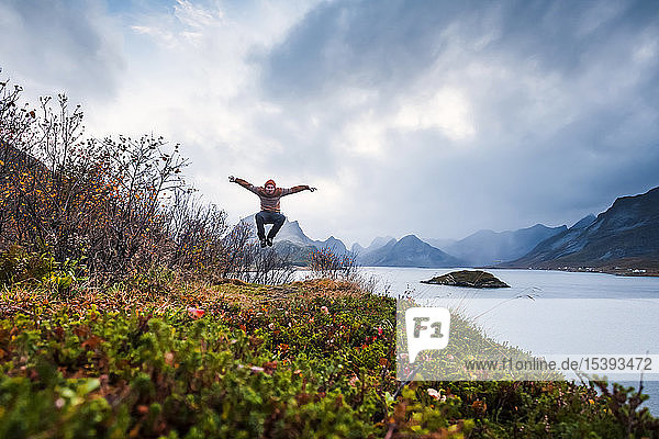 Norwegen Lofoten Mann springt an die Küste