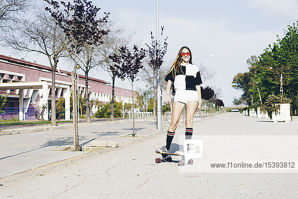 Spain  teenage girl riding skateboard on a road