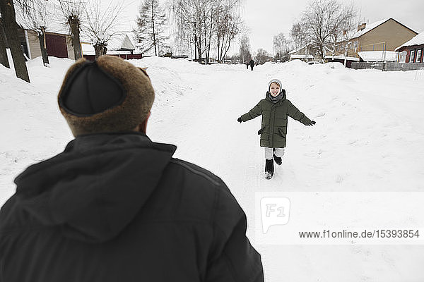 Happy grandson running to his grandfather in winter