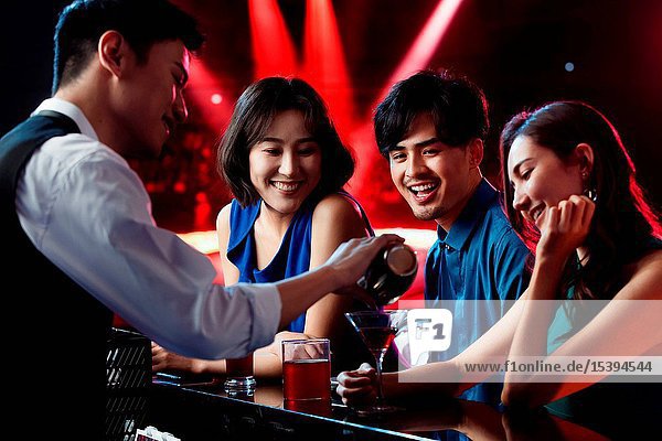 Happy young people drink at the bar