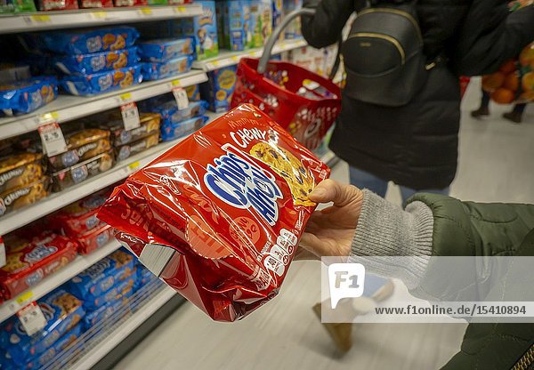 A hungry shopper chooses a package of Mondelez International's Nabisco brand Chips Ahoy! Cookies from the myriad varieties available from a supermarket shelf in New York on Monday January 28 2019. (© Richard B. Levine).