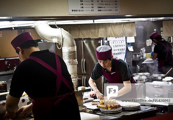 Cooks prepare takoyaki in a restaurant kitchen in Kanazawa Japan.