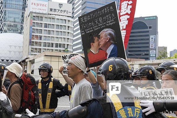 Protesters holding placards against the US President Donald Trump's visit to Japan during a rally in Shinjuku on May 26 2019 Tokyo Japan. Tokyo Police prevented a clash between a small group of right-wing people and protesters against US President Donald Trump's visit to Japan and the country's new Emperor Naruhito. Trump is currently on an official four-day state visit to Japan. He is the first foreign leader to visit the country after the coronation of Emperor Naruhito.