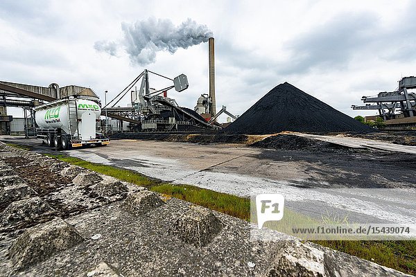 Geertruidenberg Netherlands. The Amer Centrale Power Plant is one of the fossil fuel consuming power plants producing electricity and emitting carbon and CO2 into the atmosphere. Since environmental and climate change using hard black coal and emitting greenhouse gasses became an issue. Huge stack and pile of black coal and infrastructure to transport it into the power plant.