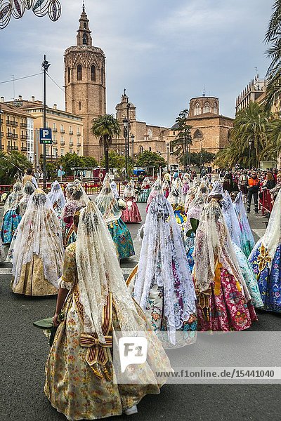 Fallas festival. Falleras. Women in traditional dress. Parade to the Plaza de la Virgin in order to make an offering of flowers to Our Lady of the Forsaken the Patron Saint of Valencia. The celebration takes place from 4 pm until past nightfall. With all of the bunches of flowers given by the falleras to the Virgin an impressive 15 metre-high tapestry is formed on the main façade of the Basilica and a mantle is made for the Virgin. Valencia. Valencian Community. Spain.