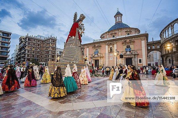 Fallas festival. Falleras. Women in traditional dress. Parade to the Plaza de la Virgin in order to make an offering of flowers to Our Lady of the Forsaken the Patron Saint of Valencia. The celebration takes place from 4 pm until past nightfall. With all of the bunches of flowers given by the falleras to the Virgin an impressive 15 metre-high tapestry is formed on the main façade of the Basilica and a mantle is made for the Virgin. Valencia. Valencian Community. Spain.