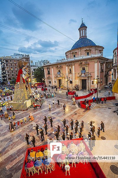 Fallas festival. Falleros and Falleras in traditional dress. Parade to the Plaza de la Virgin in order to make an offering of flowers to Our Lady of the Forsaken the Patron Saint of Valencia. The celebration takes place from 4 pm until past nightfall. With all of the bunches of flowers given by the falleras to the Virgin an impressive 15 metre-high tapestry is formed on the main façade of the Basilica and a mantle is made for the Virgin. Valencia. Valencian Community. Spain.