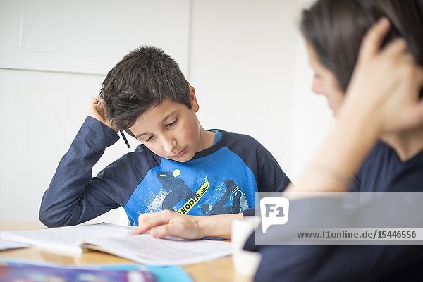 Private tutoring at home-10-11 years boy having a maths lesson at home-selective focus.