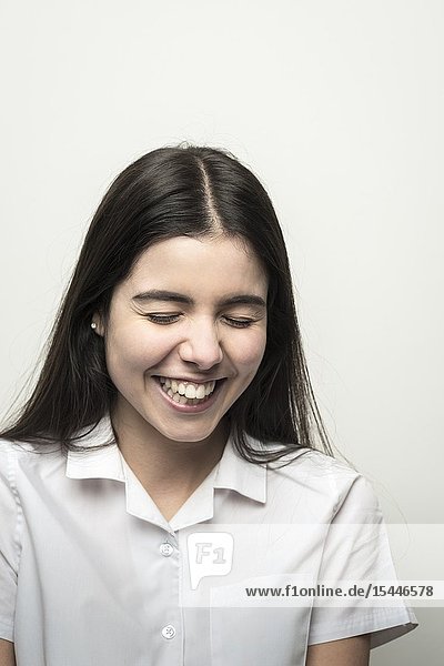 UK teenage schoolgirl with lond dark hair having a laugh.
