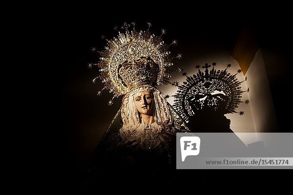 The shadow of a crowned image of the Virgin Mary is cast during Semana Santa in the church of Prado del Rey Sierra de Grazalema Cadiz province Andalusia Spain.