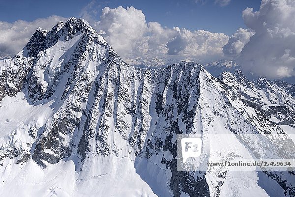 Aerial from a small plane of snow ice and rocks of Disgrazia peak north side shot in bright springtime light from Valmalenco Sondrio Italy.