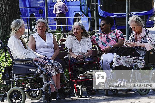 Stockholm Sweden Senior women chatting outdors while sitting in the ír strollers and wheelchairs.