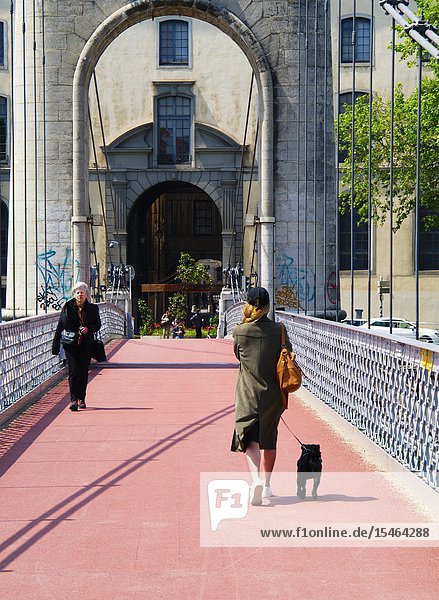 Woman with a small dog on Passerelle du College Lyon France.
