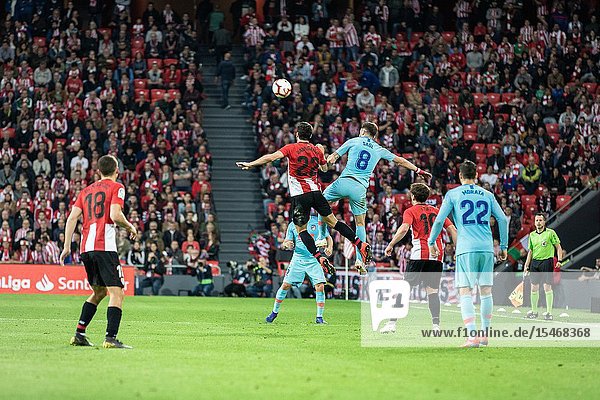 Saul Ñiguez (R) and Raul Garcia (L) jump for the ball in a Spanish League match between Athletic Club Bilbao and Athletico de Madrid at San Mames Stadium on March 16 2019 in Bilbao Spain