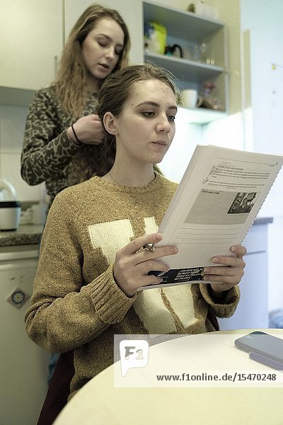 Woman learning with paper transcript in kitchen