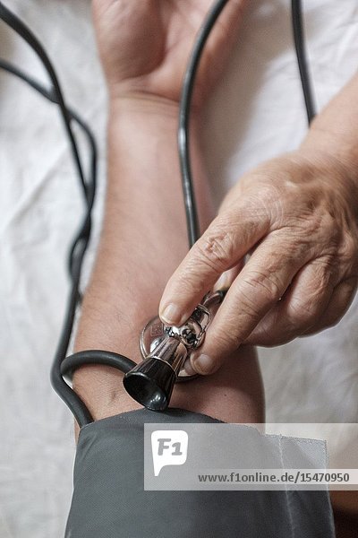 POV-Doctor checks patients blood pressure selective focus.