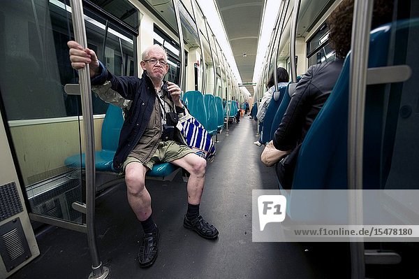 Rotterdam Netherlands. Senior adult male in shorts with skinny legs commuting by subway from Central Station towards his neighborhood.