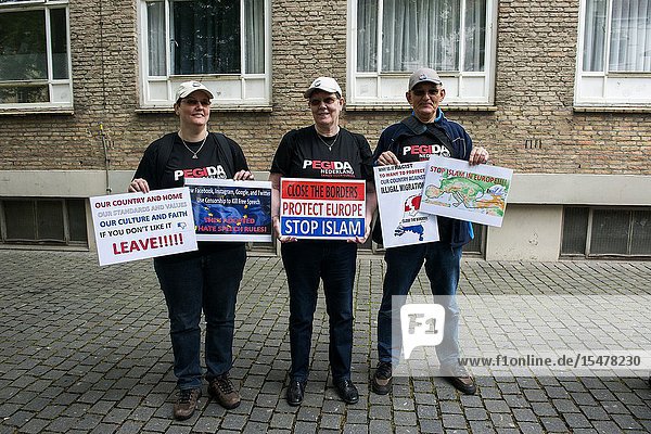 Breda Netherlands. Group of Pegida supporters with sign protesting during a local rally and demonstration. Pegida is a patriotic political organization opposing to immigration of Islamic & Muslim people into the Christian Western-European Culture.