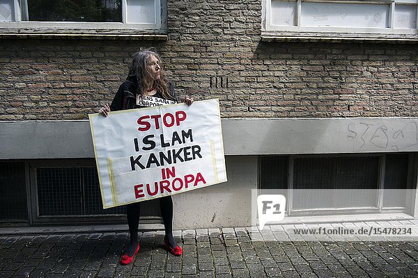 Breda Netherlands. Female Pegida supporter with sign protesting during a local rally and demonstration. Pegida is a patriotic political organization opposing to immigration of Islamic & Muslim people into the Christian Western-European Culture.