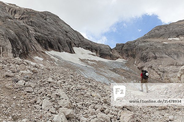 A hiker looks the Vernel Glacier Marmolada group Dolomites Canazei Trento province Trentino-Alto Adige Italy.
