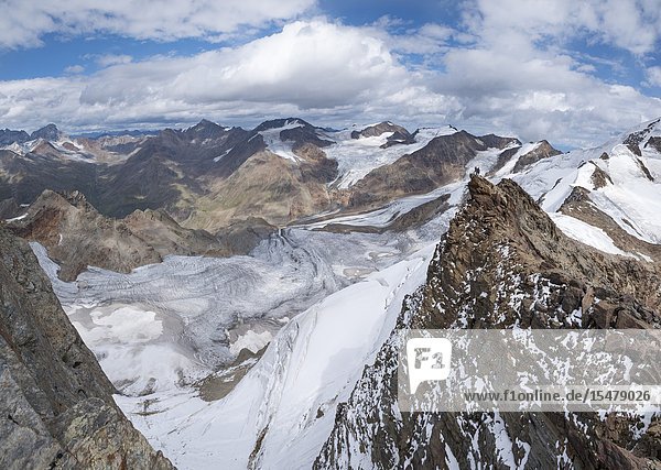 Panoramic of hikers on rocks looking at Forni glacier from Dosegù Gavia Pass Valfurva Valtellina Lombardy Italy.