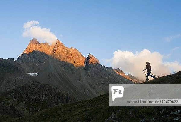 Europe Italy Lombardy Sondrio. Trekker's silhouette at sunset in the mountains of Viola valley Valtellina.