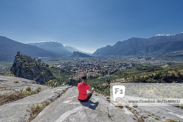 Arco Trento province Trentino Italy Europe. A Woman admires the panorama of the mountain Colodri the view extends over the city of Arco to the Lake Garda.