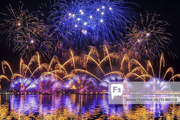 Fireworks of the feast of the Redeemer seen from Giudecca's island with church of La Salute bell tower of St. Mark and Doge's palace in the background Venice Veneto Italy.