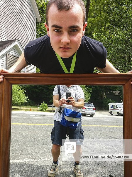 Cornwall Connectcut USA A teenage boy carries a mirror to an antique shop.