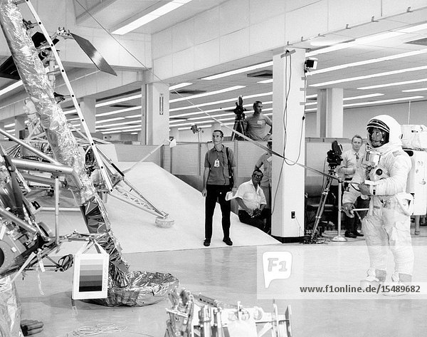 Two members of the Apollo 12 lunar landing mission participates in lunar surface extravehicular activity (EVA) simulations in the Kennedy Space Center's (KSC) Flight Crew Training Building. Here  astronauts Charles Conrad Jr.  commander  is holding the bottom end of the lunar equipment conveyor. Inside the Lunar Module (LM) and out of view is astronaut Alan L. Bean  lunar module pilot. The simulations were part of a run-through of the Apollo 12 lunar surface timeline.