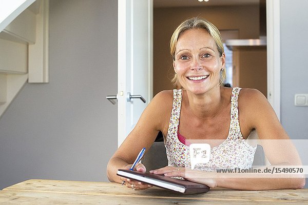Kaatheuvel Netherlands. Young blonde woman with her analog planner just after making an appointment.