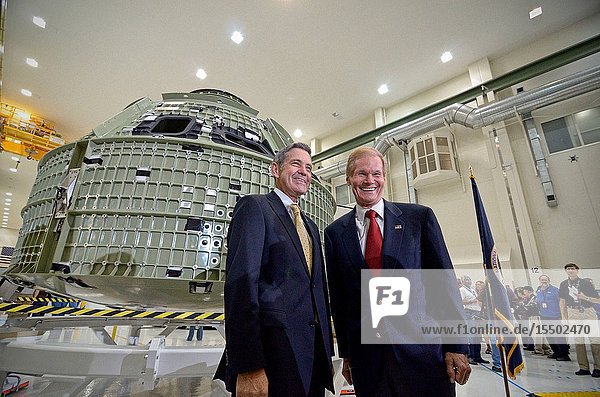 Inside Kennedy Space Center's Operations and Checkout Building KSC Director Bob Cabana (left) and U.S. Senator Bill Nelson are pictured with NASA's first space-bound Orion capsule following its arrival in Florida. Out of frame are approximately 100 guests on hand to celebrate the event. Slated for Exploration Flight Test-1 an uncrewed mission planned for 2014 the capsule will travel farther into space than any human spacecraft has gone in more than 40 years. The capsule was shipped to Kennedy from NASA's Michoud Assembly Facility in New Orleans where the crew module pressure vessel was built. The Orion production team will prepare the module for flight at Kennedy by installing heat-shielding thermal protection systems avionics and other subsystems.