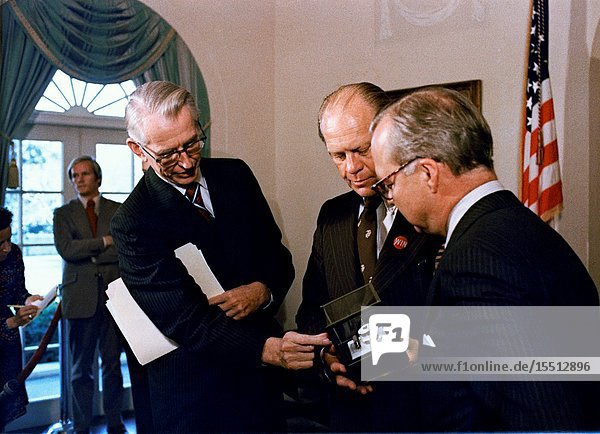 Dr. James C. Fletcher left NASA Administrator explains the formation of the indium-antimonide crystal manufactured in space to President Gerald R. Ford at the White House. Standing at right is Harold Johnson Chairman of the Massachusetts Institute of Technology. The segment of indium-antimonide is cut from a cylindrical single crystal that was partially melted and resolidified aboard the Skylab space station on Jan. 6 1974 during the third and final manned flight. This segment is approximately one by one centimeters and about three millimeters thick. The sequence of heating and cooling was started and supervised by the members of the third Skylab crew astronauts Gerald P. Carr Edward G. Gibson and William R. Pogue. The crystal forming was accomplished in a special multipurpose furnace known as the Materials Processing Facility (Skylab Technology Experiment M512).