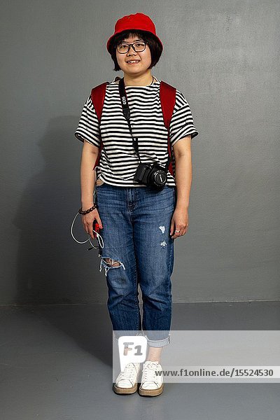 Tilburg Netherlands. Young female Chinese tourist with camera roaming the city for images and memories. Studio Portrait.